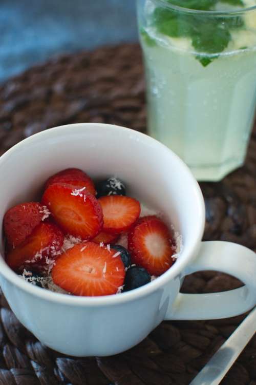 Cup of oatmeal with berries and coconut