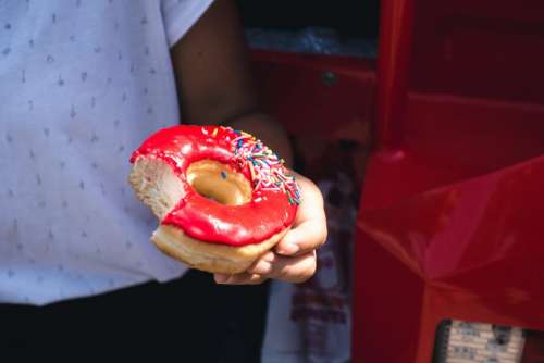 Girl holding a red donut