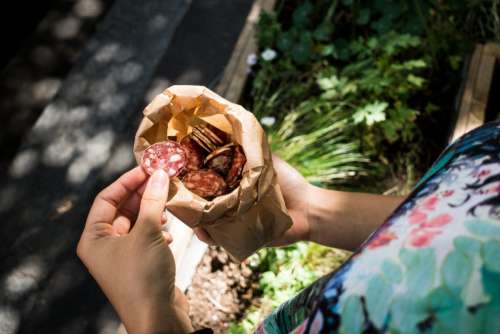 Girl snacking on organic sausage