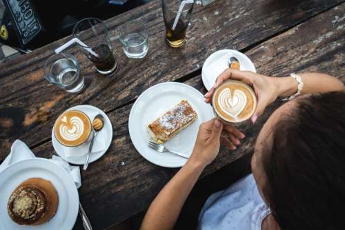 Girl treating herself with flatwhite coffee and cake