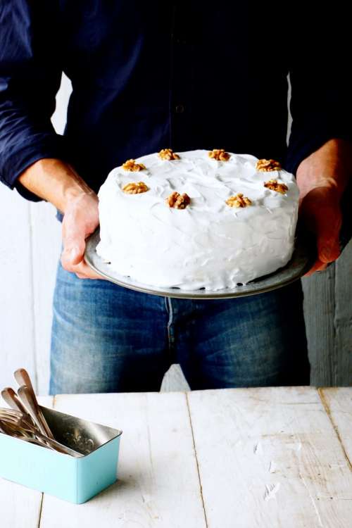 Man holding carrot cake with icing