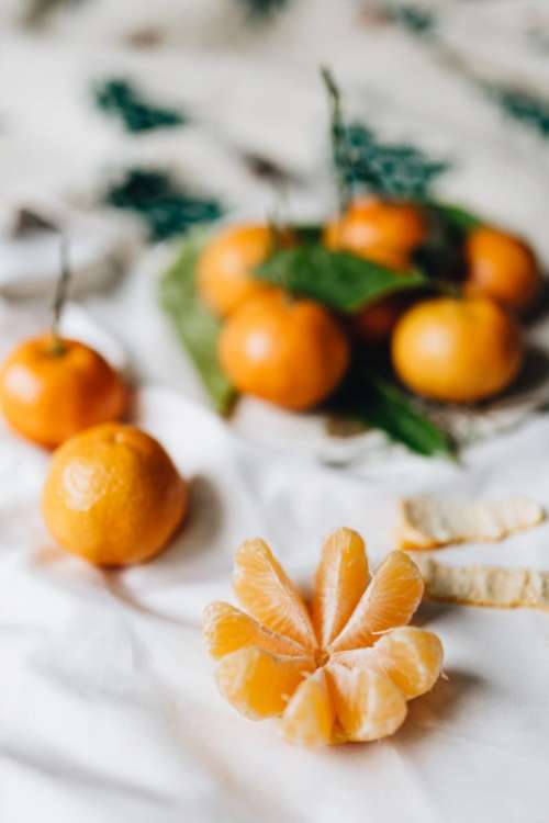 Tangerins with leaves on a white linen