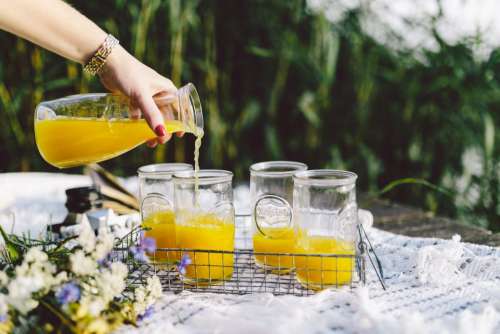 Pouring orange juice on picnic
