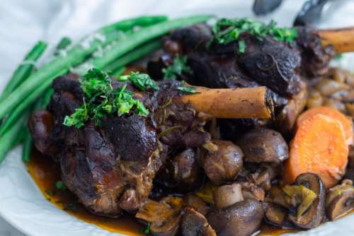 Rosemary lamb shanks with mushrooms and vegetables on wine