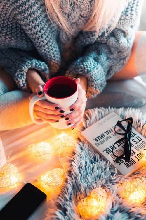 Woman in a winter mood with hot tea and a book