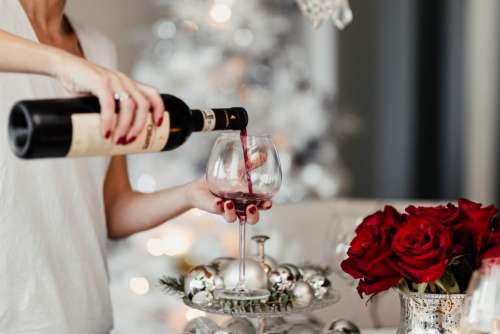 Woman pouring red wine in a glass