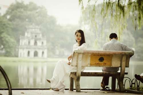 Couple sitting on a bench at Ho Guom at Hanoi, Vietnam free photo