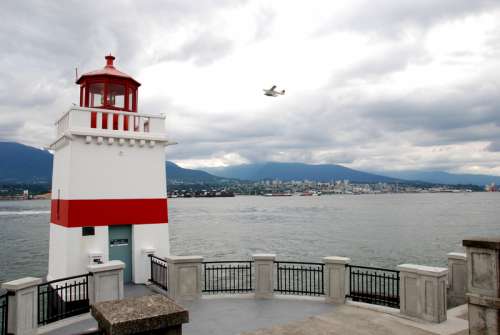 Lighthouse with plane flying in Vancouver Port in British Columbia, Canada free photo