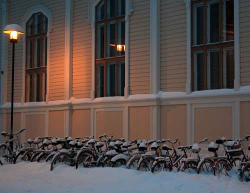 Snowy bicycles in front of library of architecture of Oulu University in Finland free photo