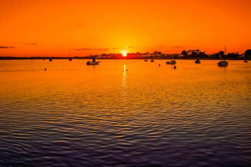 Sunset over the waters with boats at Christchurch, England free photo