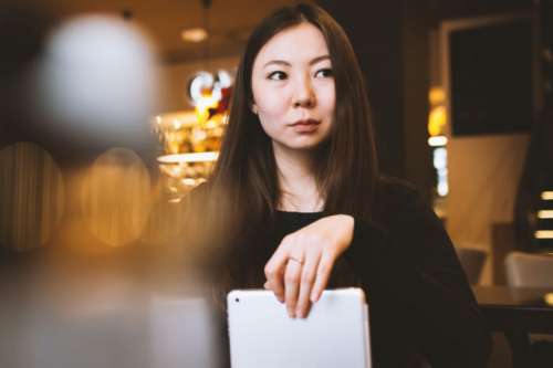 Young college student in a cafe with tablet in hand