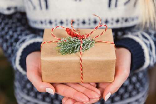 Woman’s hands hold christmas gift box. Merry Christmas