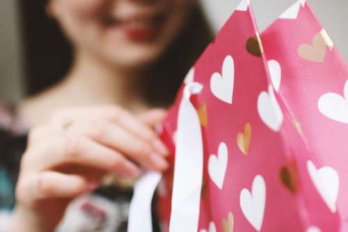 Young girl unpacking a gift. Valentine’s Day.
