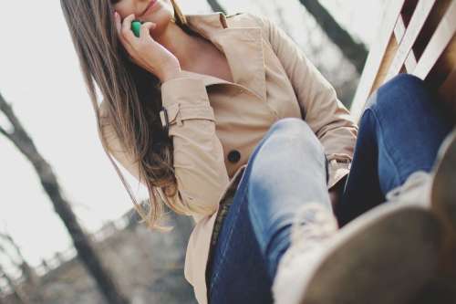 Young businesswoman on the phone on a park bench
