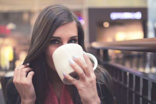 Portrait of young girls while drinking coffee in a shopping center