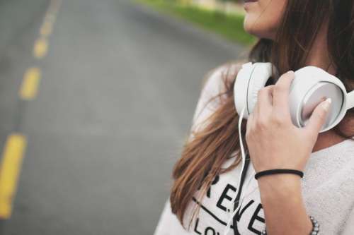 Girl with headphones on her neck in street
