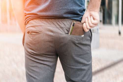 Man’s hand taking wallet from his own pocket