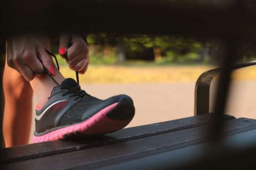 Woman obliges shoelaces on sports shoe