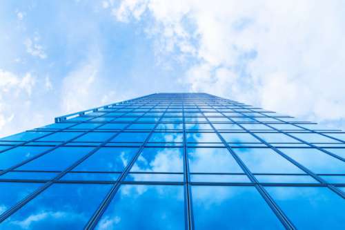 Sky with clouds in the reflection in windows of modern office building