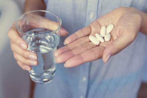 Hands of girl holding pills