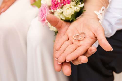 Bride and groom’s hands with wedding rings