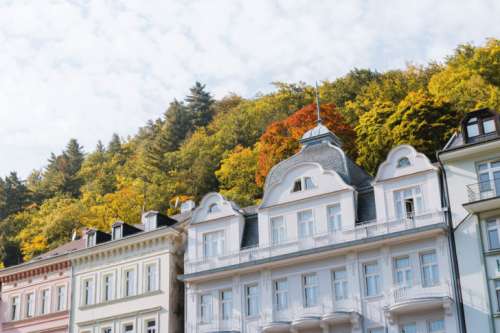 Tall hotels and traditional buildings on sunny street in Karlovy Vary