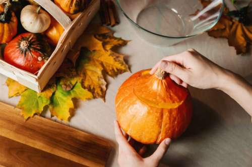 Girls hands carve the pumpkin. Halloween.