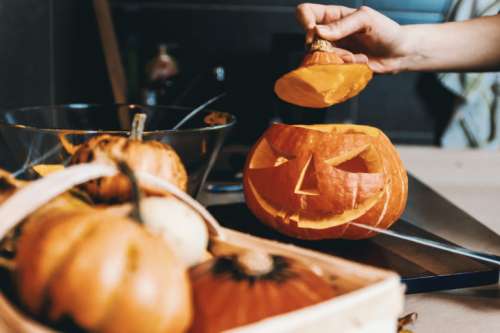 Girls hands carve the pumpkin. Halloween.