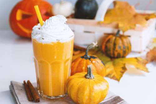 Pumpkin smoothie. Small pumpkins and drink on the white background