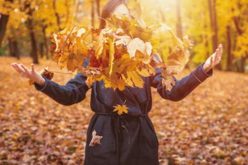 Woman Throwing Autumn Leaves Into The Air