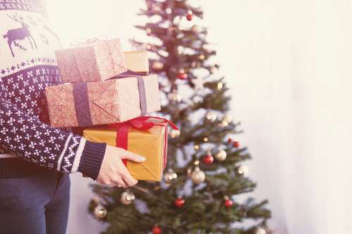 Woman’s hands hold christmas gift boxes. Merry Christmas