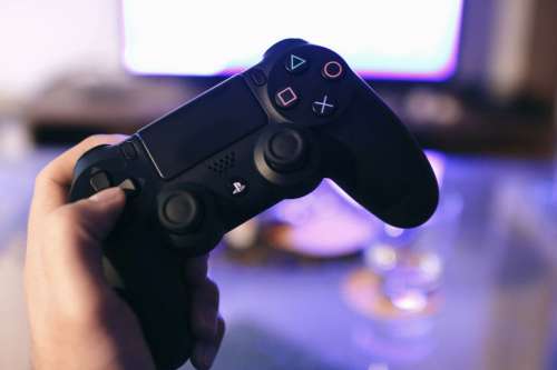 Detail gaming controller for the PlayStation console in the hand of player