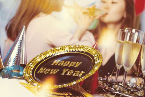 Happy New Year Concept. Two young girls holding glasses of champagne making a toast.