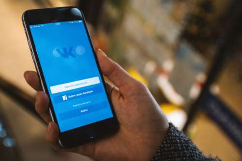 Display with login to the social network Vkontakte on modern smartphone in hands