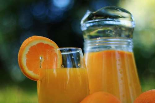 Glass and weighs detail with orange juice in nature