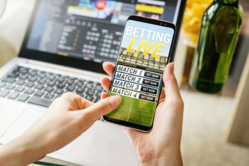 Close-up view of young woman betting with her mobile phone.