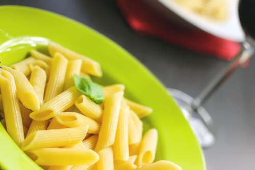 Pasta in a green plate with basil