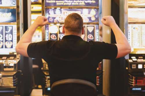 Man playing the slot machine at casino