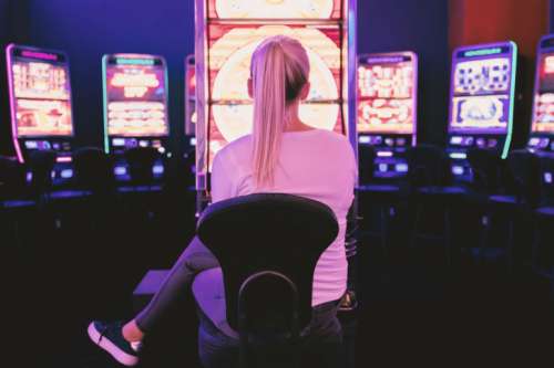 Young woman playing at slot machine in casino