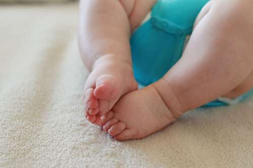 The newborn and his little feet on a blanket