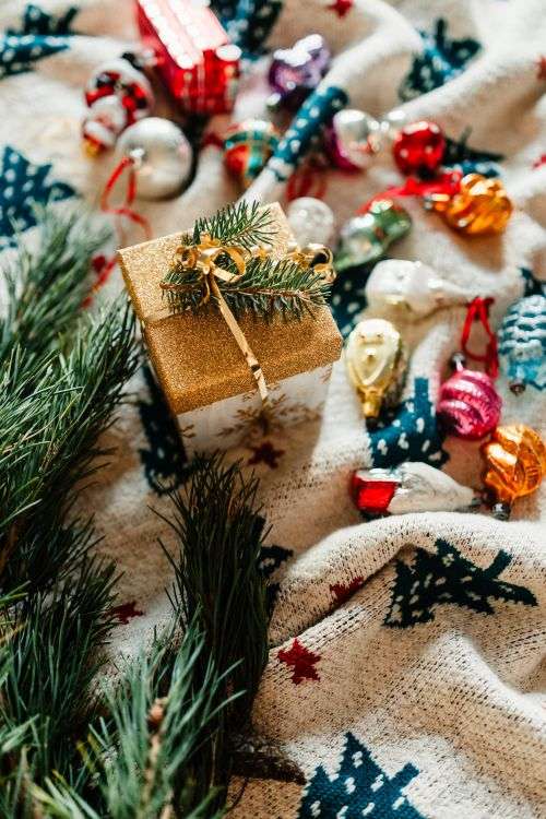 Christmas gift and colourful tree decorations on a blanket
