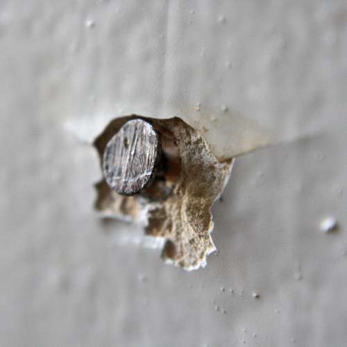 Nail Head Sticking out of Wall