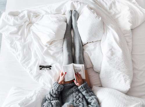 Woman Reading a Book in Bed