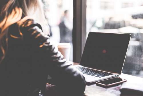 Digital Nomad Millennial Student Girl Working Remotely from Café