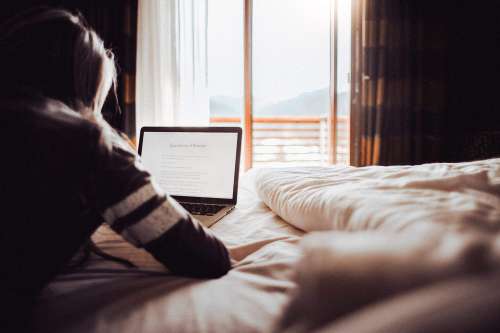 Girl Reading a Blog in a Bedroom