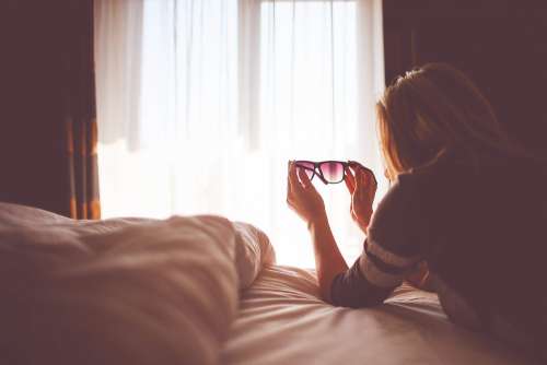 Girl with Sunglasses in a Bed
