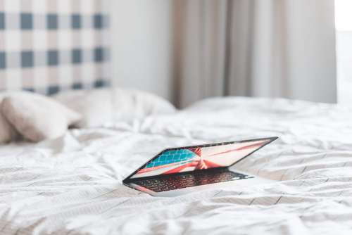 Laptop Lying in a Bed