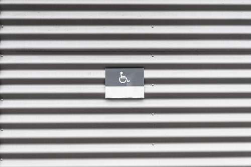 Metal Wall with Wheelchair Disabled Sign
