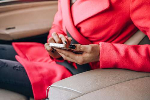 Nicely Dressed Woman Using Her Phone in a Car