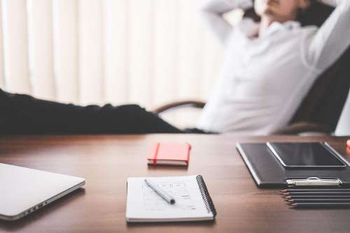 Man Relaxing in Office With Legs Up: All Work Done